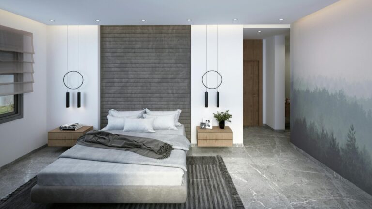A bedroom with wallpaper, a grey headboard, and carpet