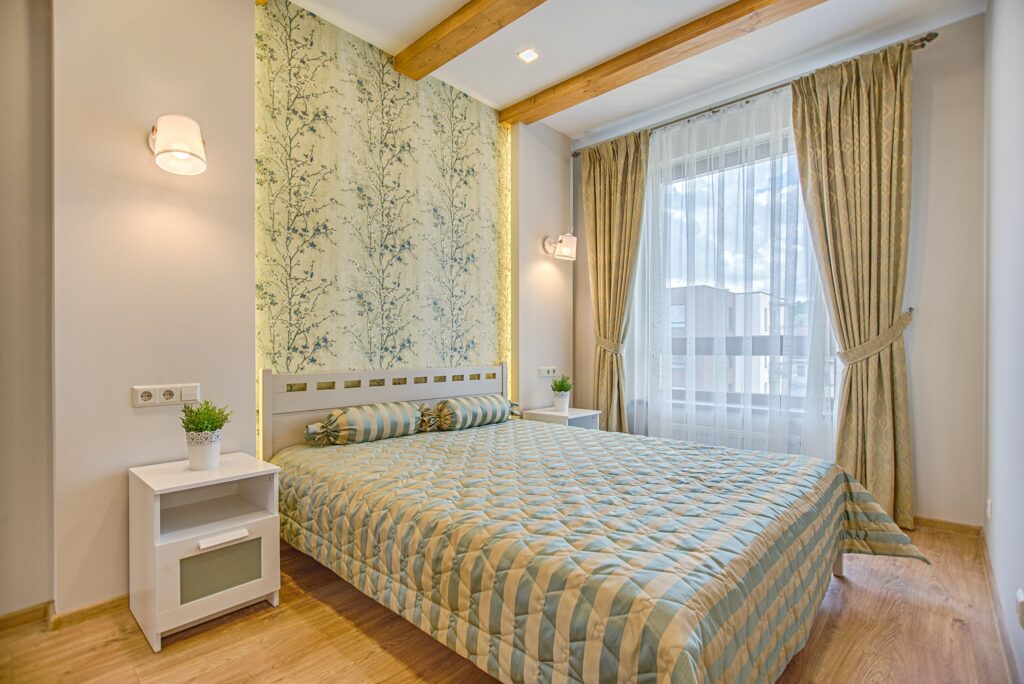 A bedroom with a motif green and yellow both in bedsheet and wallpaper background