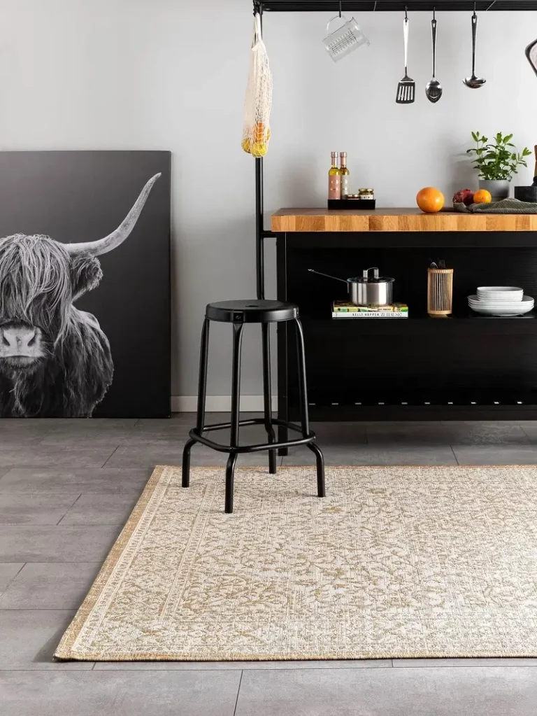 An indoor carpet in a beige color with a background of a wall painting and a coffee corner