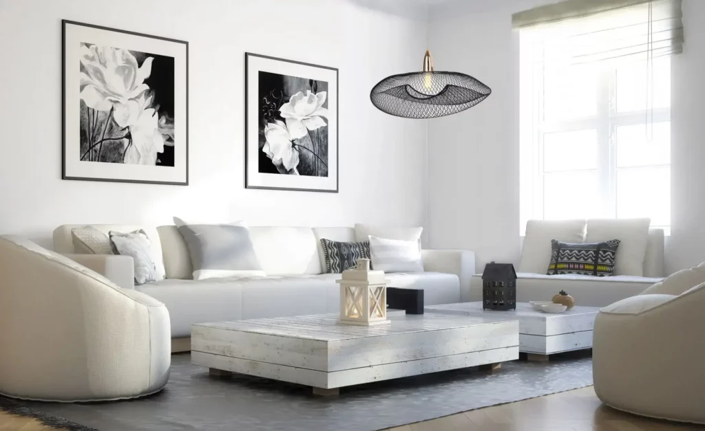 Una escena de salón con una paleta de colores en blanco y negro y una iluminación de acento con colgantes.
