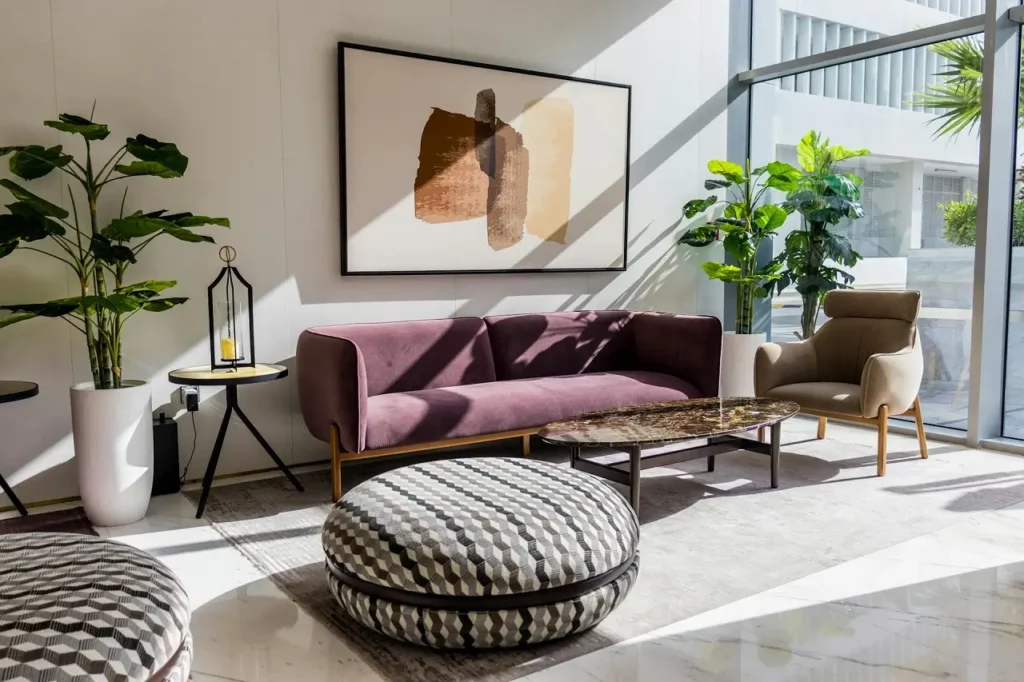 A living room with direct sunlight and a plant on the side.