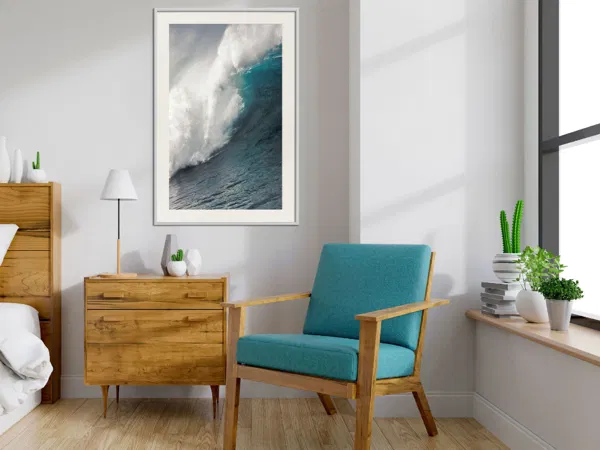 A cozy corner with a wall poster of ocean in blue and green color.