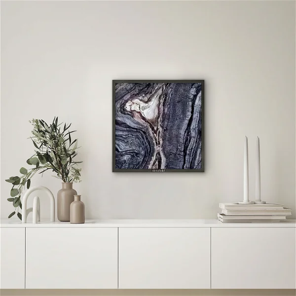 A living room corner with a marble art painting hanged on the wall.