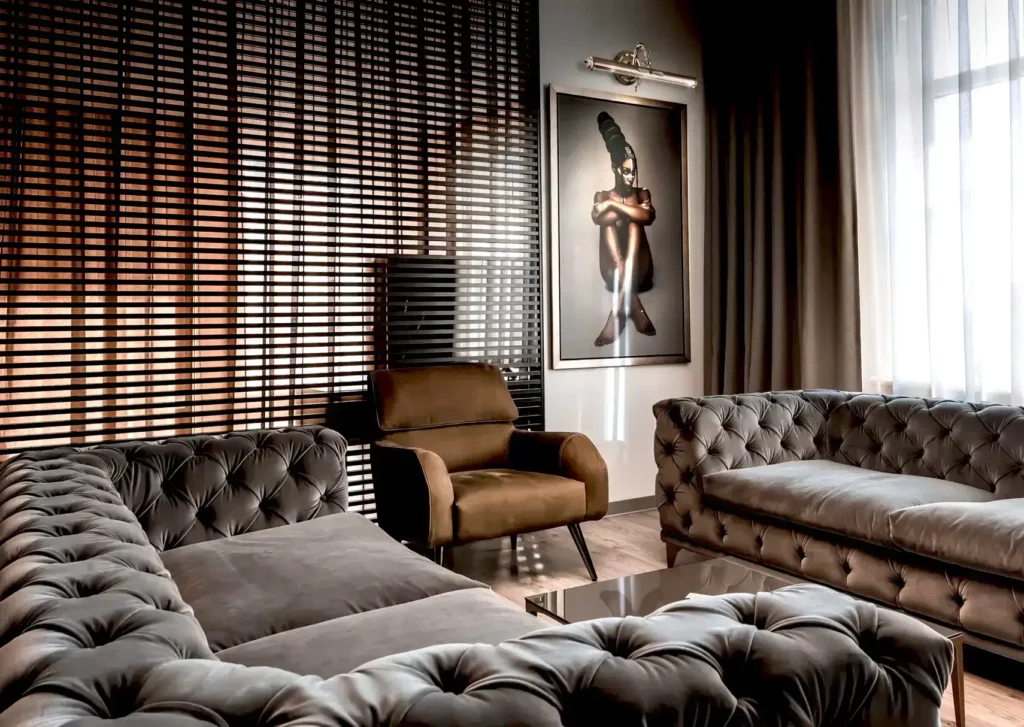 A living room with a brown and gray theme with a wall painting of a woman.