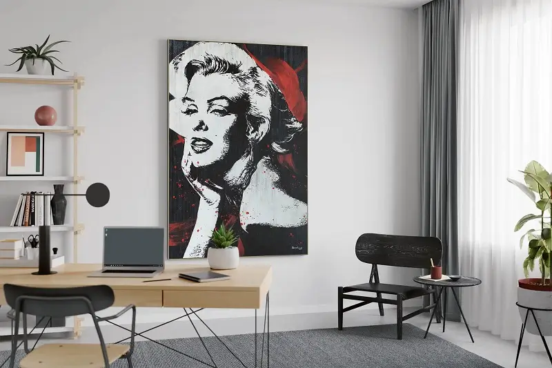 An office space with a large painting of a woman in white, black and red color.