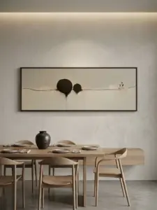 A wide panoramic minimalist painting featuring abstract black shapes and simple lines, displayed above a wooden dining table setup.