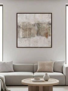 Minimal living room with square textured wabi-sabi artwork above a neutral sofa.