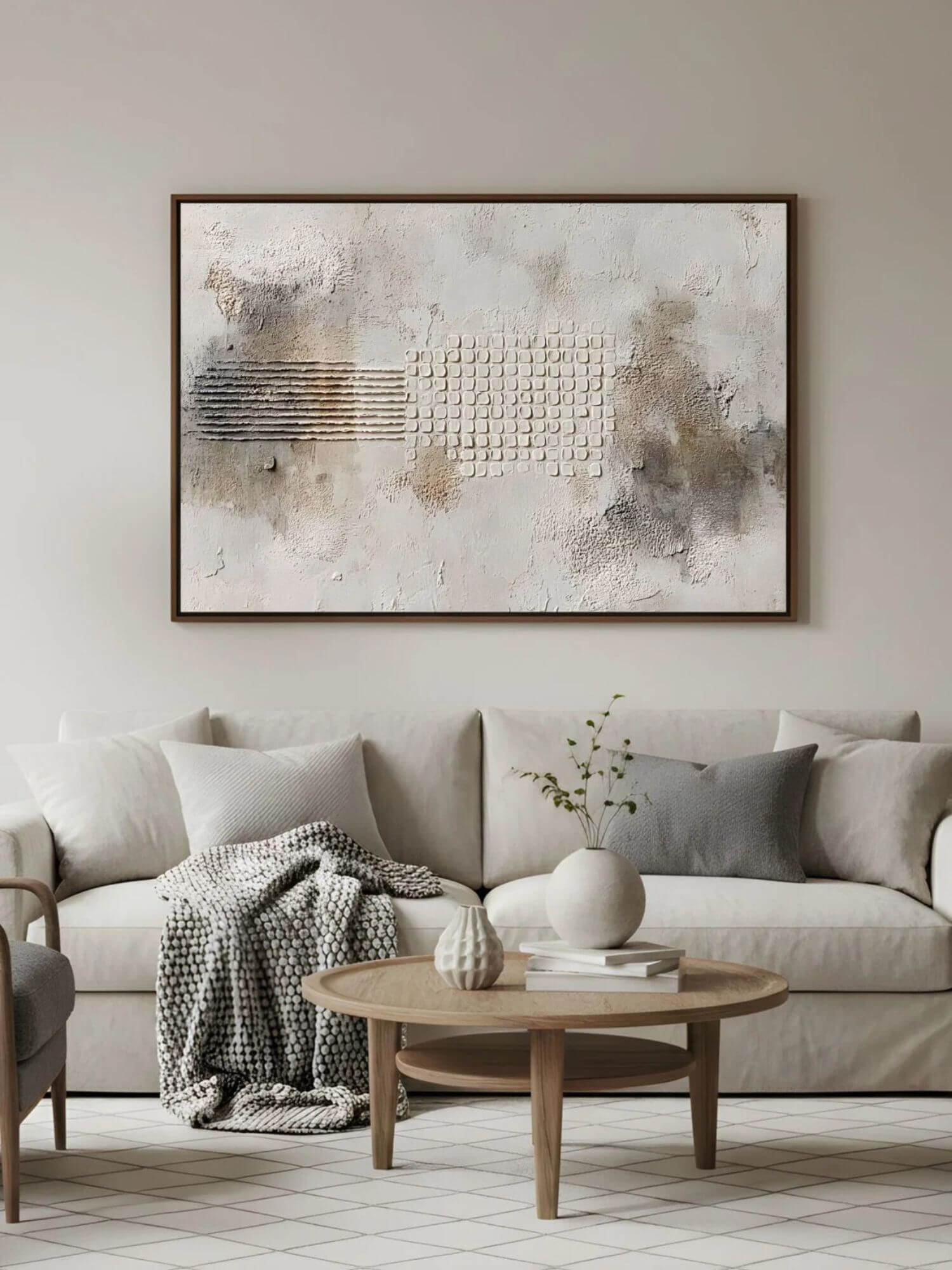 Minimal living room with square textured wabi-sabi artwork above a neutral sofa.